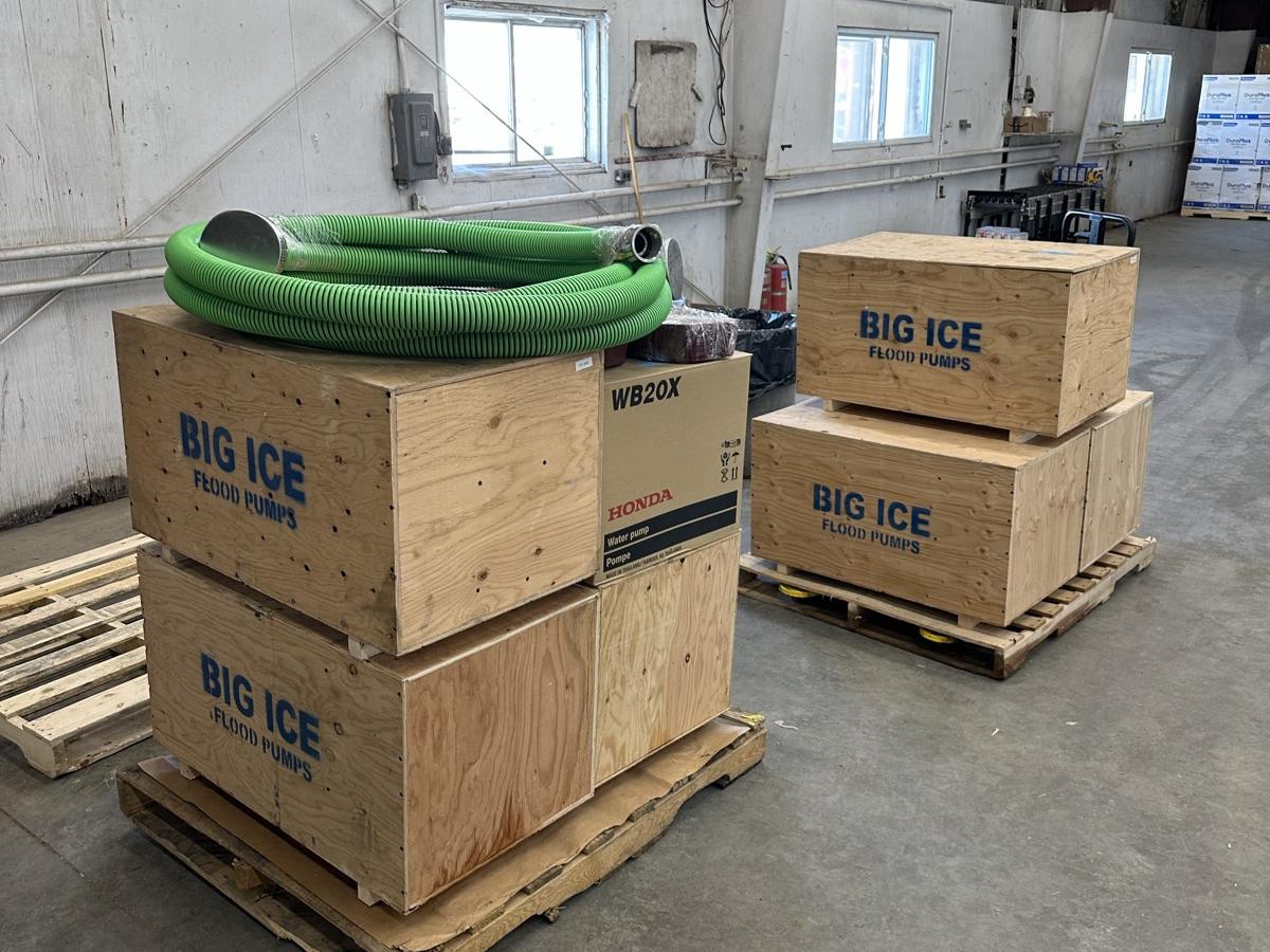 Crated pumps and hose staged in the warehouse before a job