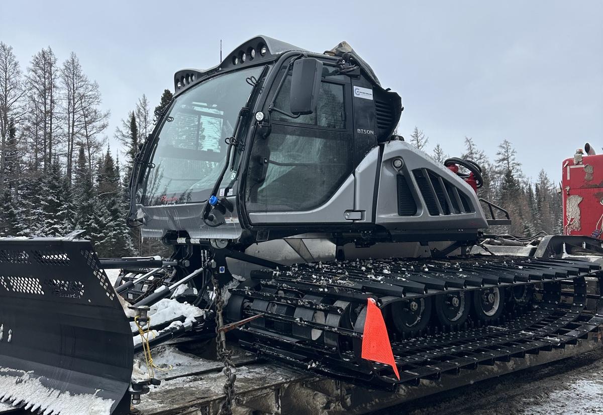 A tracked groomer loaded on a lowboy for the winter road