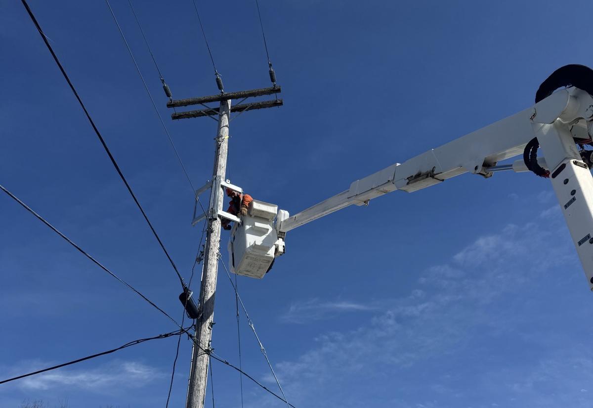 A lineman working from a bucket on a hydro pole